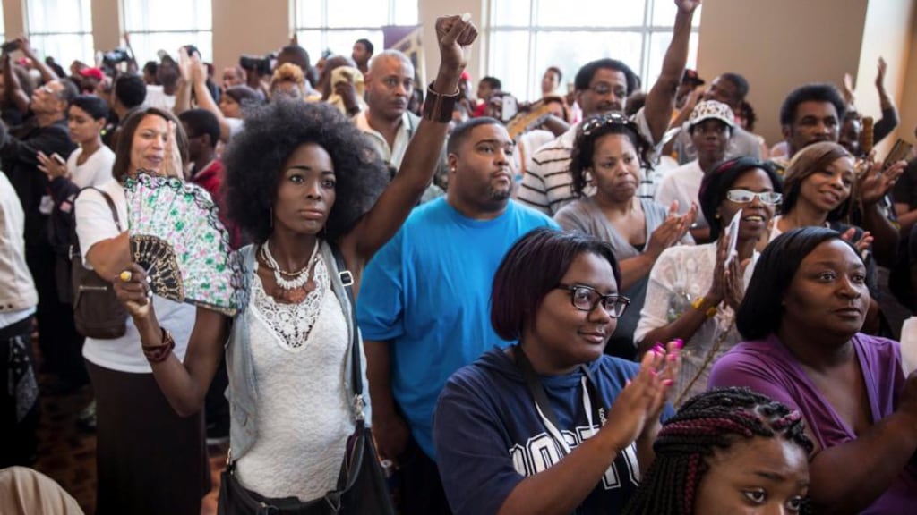 Ali Delan joins a capacity crowd that spilled outside at the Greater Grace Church during a rally for Michael Brown (18), the unarmed black man who was fatally shot by a white police officer last week. Photograph: Whitney Curtis/The New York Times