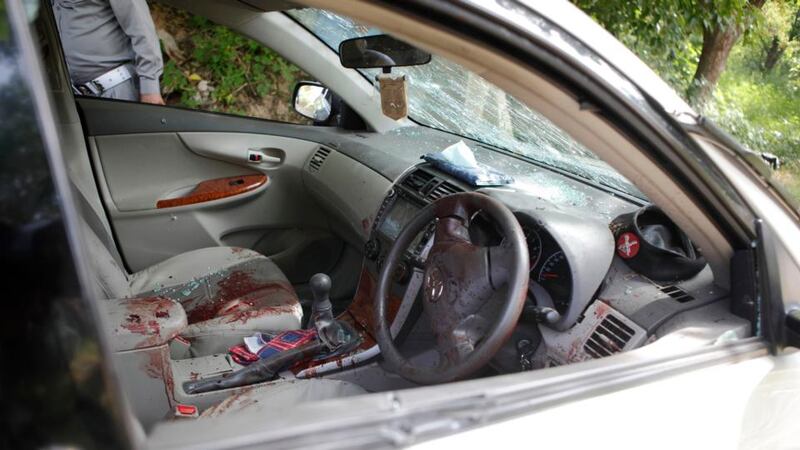A security official stands near the damaged car in which Chaudhry Zulfikar was travelling in, when it came under attack by unidentified gunmen, in Islamabad today. Photograph: Mian Khursheed/Reuters