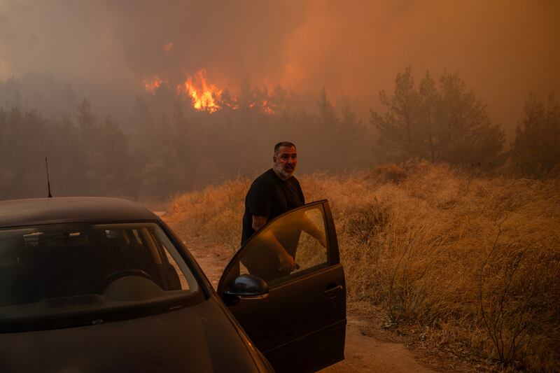 Residents evacuate as wildfire intensifies in Dione, Greece. Photograph: Angelos Tzortzinis/AFP via Getty Images