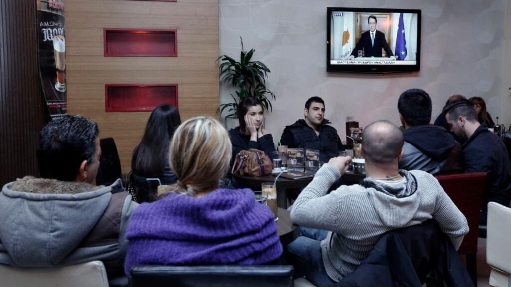 Cypriots watch in a Nicosia cafe as President Nicos Anastasiades addresses the nation yesterday following the agreement of a bailout deal with the European Union and International Monetary Fund. Photograph: Reuters