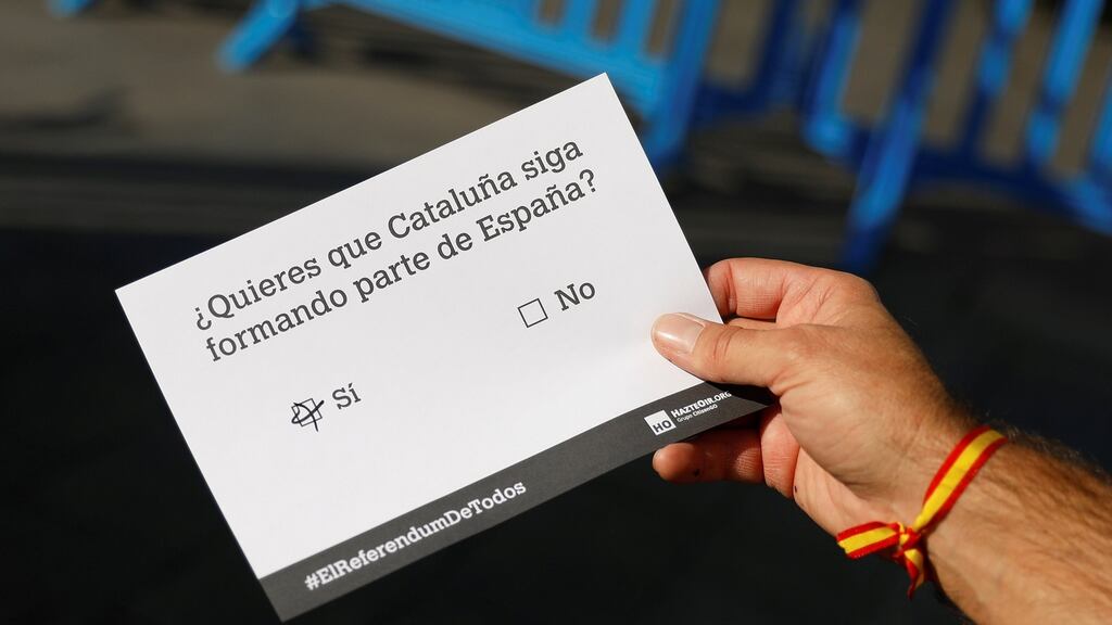 A man holds a dummy ballot before participating in a symbolic vote organised two days before a banned independence referendum in Spain’s northeastern region of Catalonia. Photograph: Reuters/Rafael Marchante