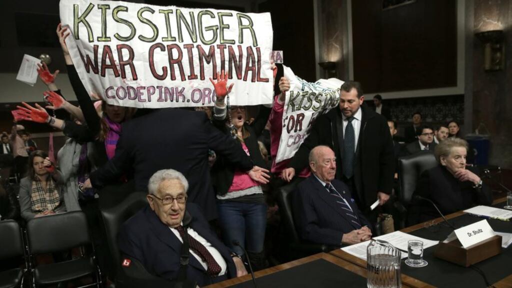 Protesters shout “Arrest Henry Kissinger for war crimes” as (L-R) Mr Kissinger; and former US secretaries of state George Shultz and Madeleine Albright appeared before the Senate Armed Services Committee in Washington, DC. Photograph: Win McNamee/Getty Images.