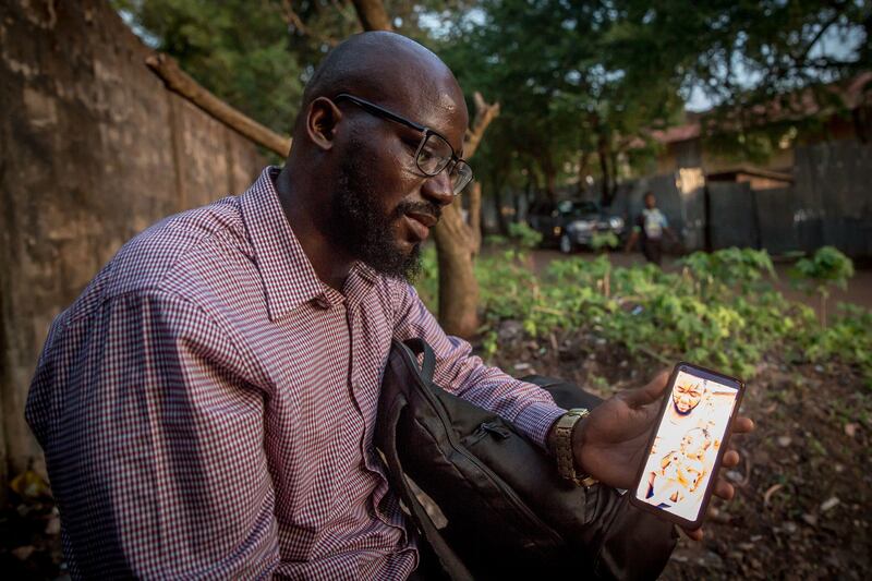 Alusine Koroma holds a picture of his half brother Hassan Dumbuya, who was killed by police in the days after the August 10th protests. Photograph: Sally Hayden