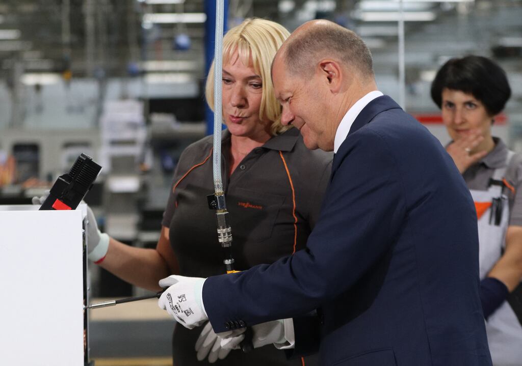 A gloved German chancellor Olaf Scholz gets to grips with a heat pump at a Viessmann plant in Allendorf, western Germany. Photograph: Yann Schreiber/AFP