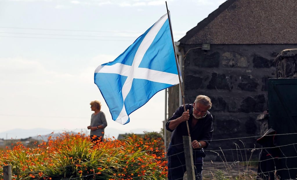 A man erects a Scottish flag in the garden of his cottage on the Isle of Lewis in the Outer Hebrides yesterday. Photograph: Reuters