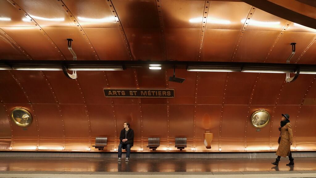 Commuters wait on a platform at the metro station Arts et Metiers, which is covered with copper panels, in Paris. Photograph: Gonzalo Fuentes/Reuters