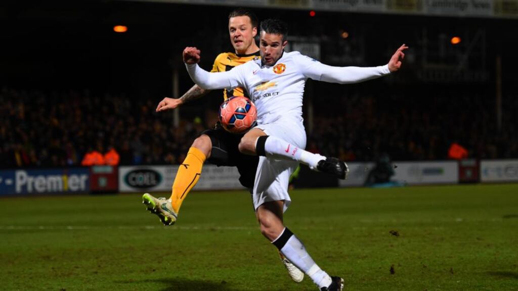 Robin van Persie of Manchester United shoots at goal under pressure from Josh Coulson of Cambridge United during the FA Cup fourth-round match at The Abbey Stadium. Photograph: Shaun Botterill/Getty Images