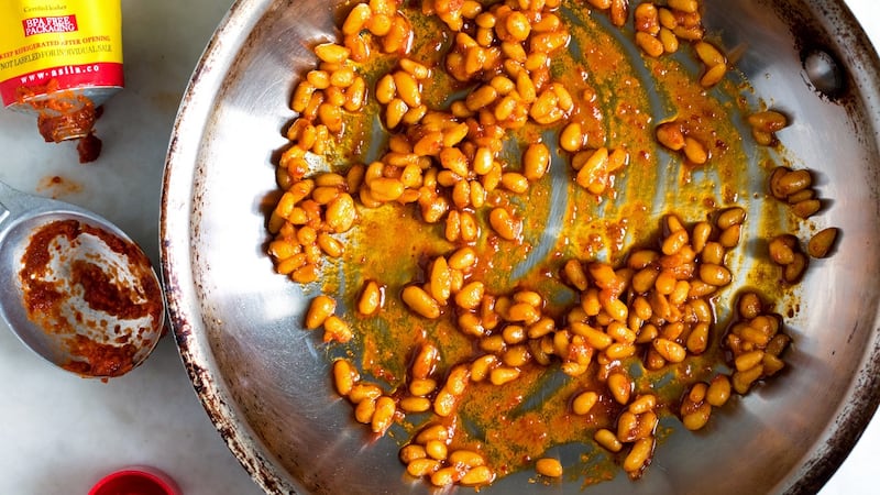 Harissa pine nuts are cooked until golden and used to top the salad.