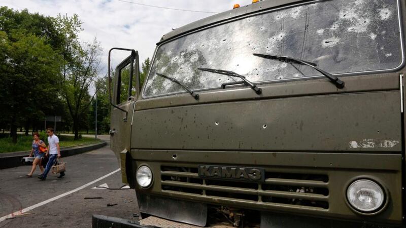 A couple walks past a wrecked truck used by pro-Russian rebels  near Donetsk airport. Photograph: Yannis Behrakis/Reuters