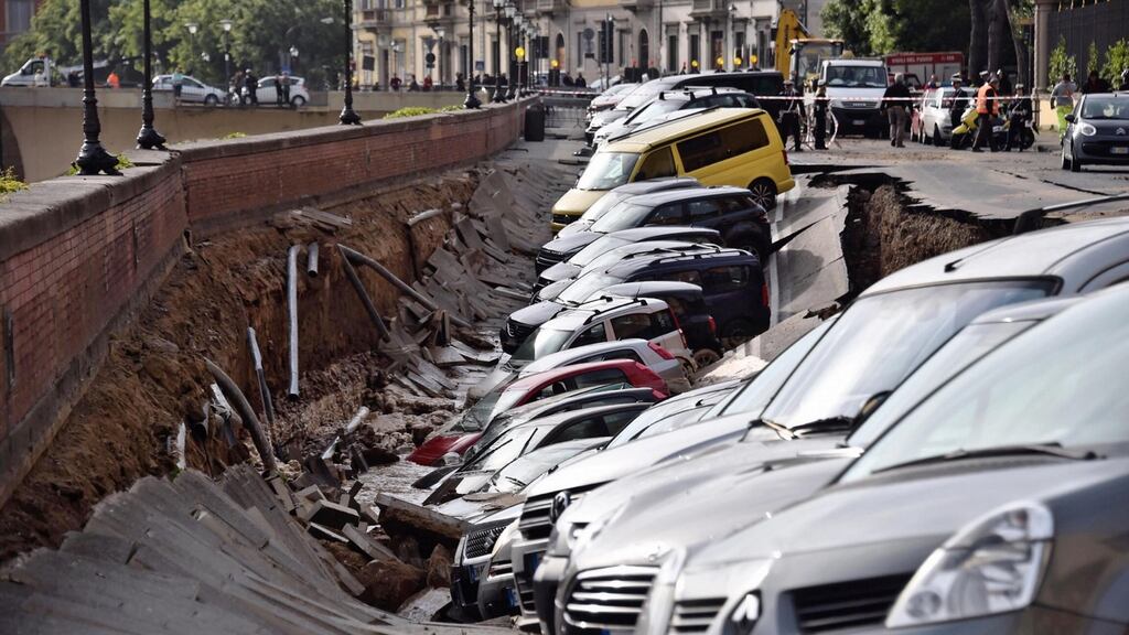 Parked cars engulfed in a crater that opened next to the river Arno in Florence on Wednesday morning. Photograph: Maurizio degl’Innocenti/ANSA via AP.