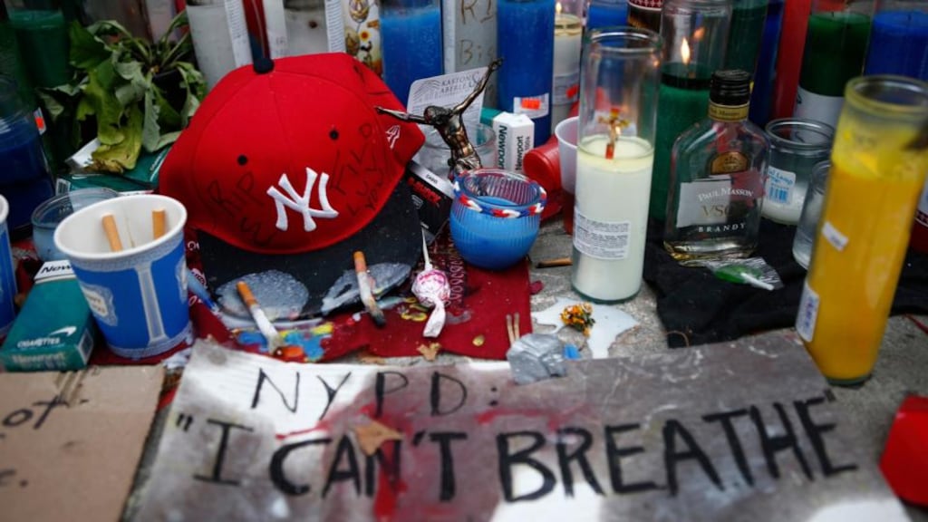 Candles are seen at a memorial for Eric Garner in Staten Island, New York last year. New York City has reached a settlement with the family of Mr  Garner, who died after being put in a chokehold by police last July, agreeing to pay $5.9 million to resolve the claim. Photograph: Eduardo Munoz/Reuters.