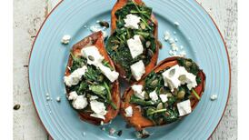 Baked sweet potato with feta cheese, spinach and chilli pumpkin seeds