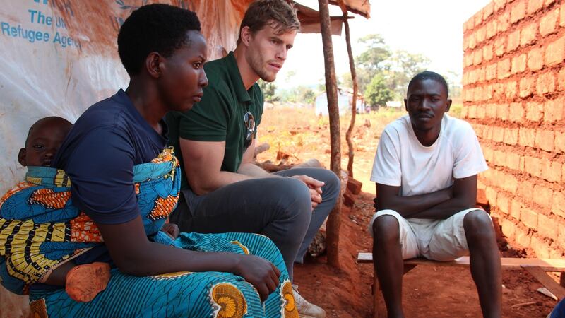 Burundian refugees Belange with her one-year-old son Remy and husband Habonimana meet Oxfam Ireland ambassador Andrew Trimble outside their tent in the Nduta camp in Tanzania. Photograph: Bill Marwa/Oxfam