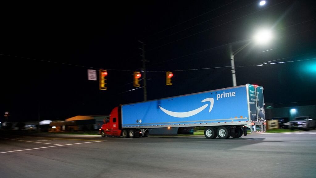 A truck carries a trailer with the Amazon Prime logo past the Amazon.com BHM1 fulfullment center in Bessemer, Alabama.