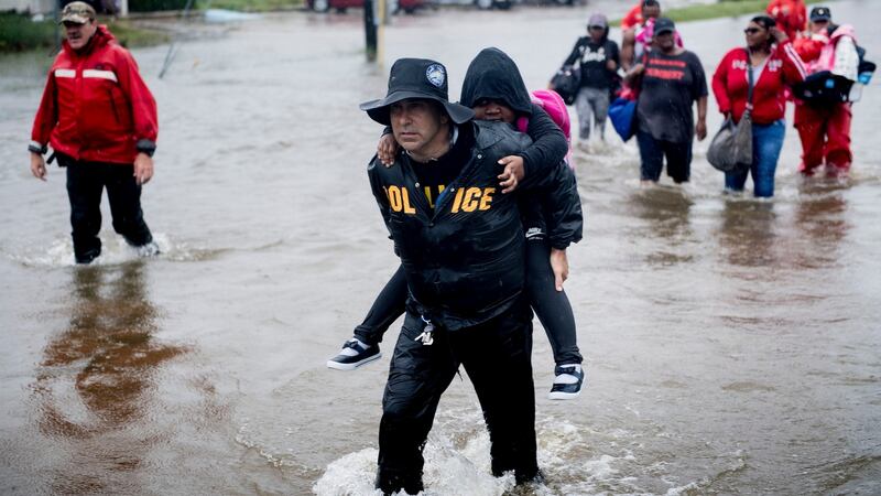 People walk to a Harris County Sheriff air boat while escaping a flooded neighbourhood during the aftermath of Tropical Storm Harvey in Houston, Texas. Photograph: Brendan Smialowski/AFP/Getty Images
