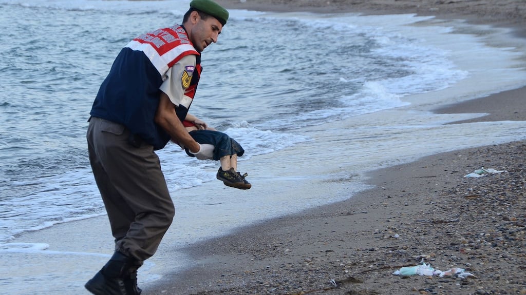 A Turkish police officer carrying Alan Kurdi’s body off the shore in Bodrum, southern Turkey, after a boat carrying refugees sank while heading to the Greek island of Kos. Photograph: Nilufer Demir/AFP/Getty Images