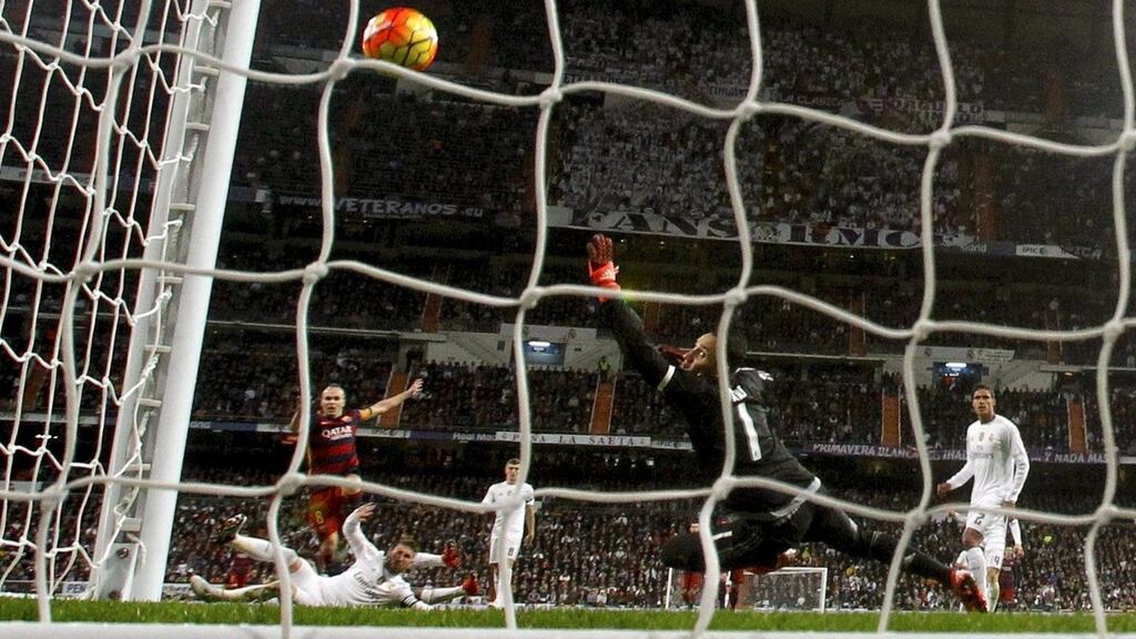 FC Barcelona’s midfielder Andres Iniesta (L) scores the 0-3 lead against Real Madrid’s Costa Rican goalkeeper Keylor Navas (C) during the Spanish Liga Primera Division match at Santiago Bernabeu stadium Photograph: JuanJo Martin/EPA