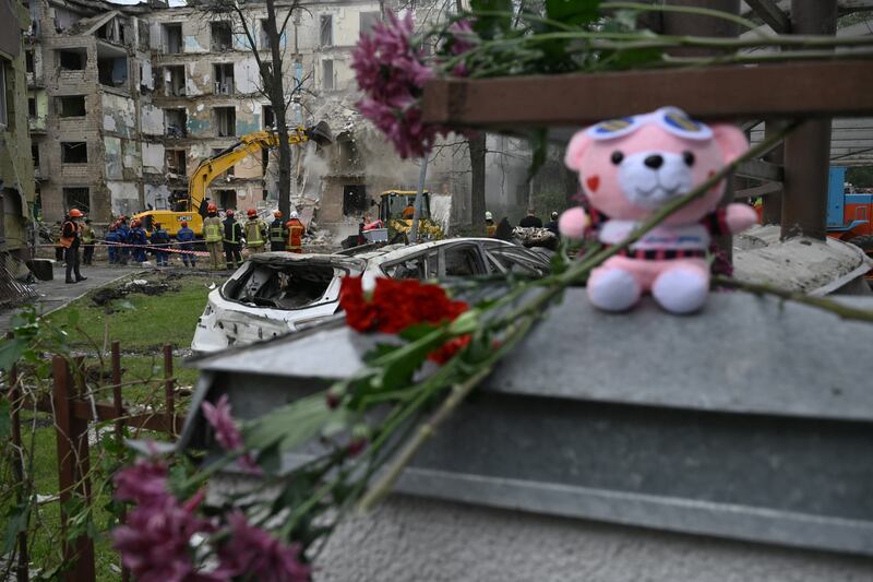 Flowers and a teddy placed in memory of victims following a Russian missile strike on a residential building. Photo by Genya Savilov/AFP