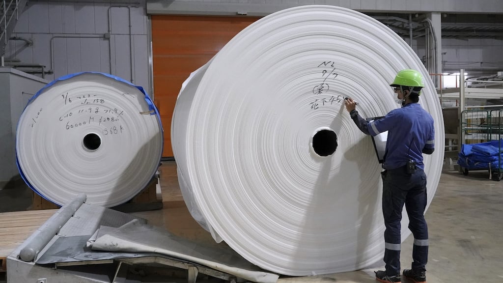 A worker checks a spool of recycled paper at a Corelex Shinei Co. toilet paper factory in Fuji, Shizuoka Prefecture, Japan. Photographer: Toru Hanai/Bloomberg