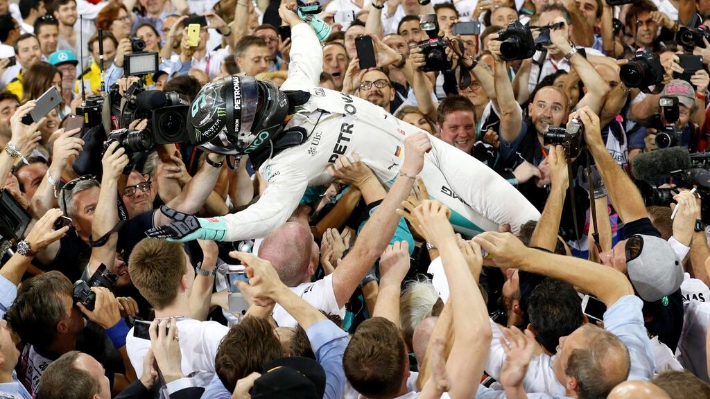 Nico Rosberg is carried by fans after winning the Formula One world championship. Photo: Ahmed Jadallah/Reuters