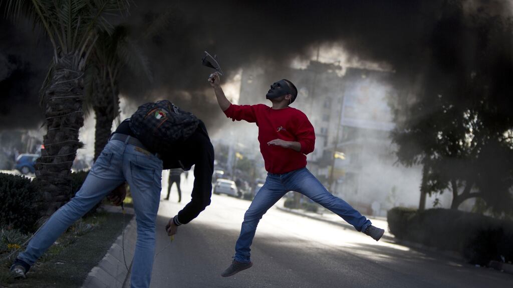A Palestinian protester uses a sling shot to hurl stones at Israeli troops during clashes obn Friday in the West Bank city of Ramallah. Photograph: Majdi Mohammed/AP