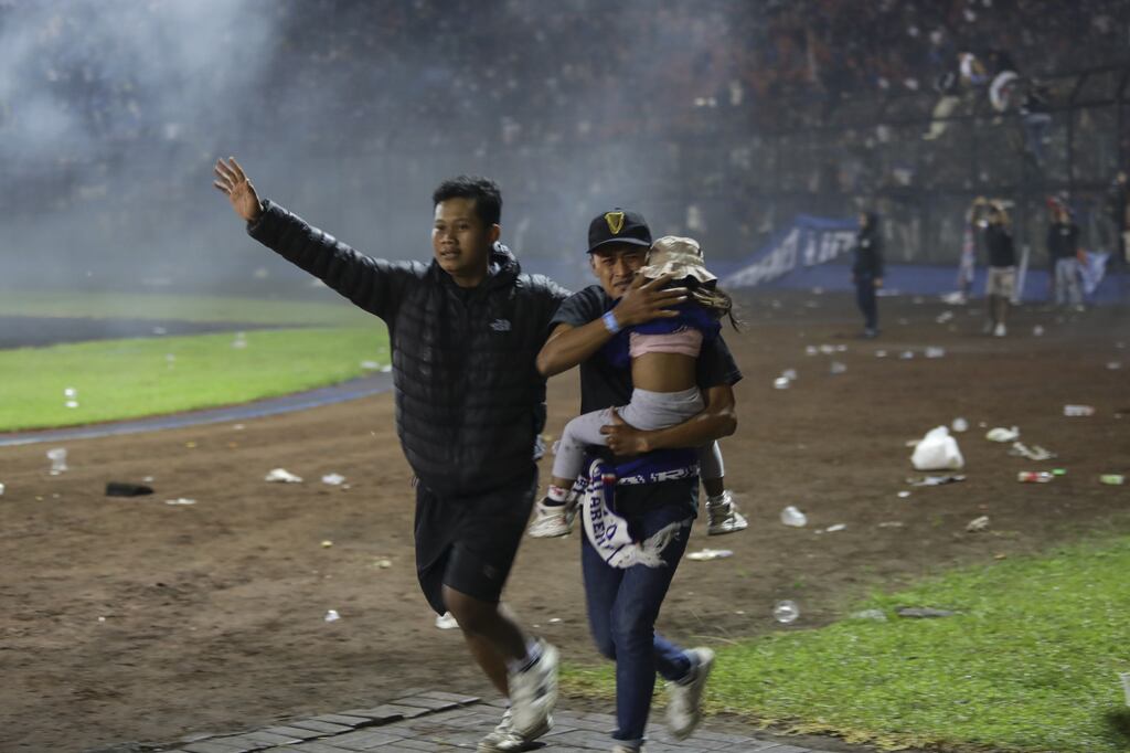 Soccer fans evacuate a girl during the chaos at Kanjuruhan Stadium in Malang. Photograph: H Prabowo/EPA