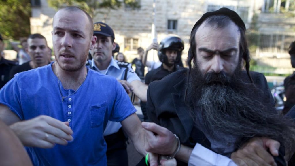 Israeli policemen arrest Yishai Schlissel on suspicion of stabbing participants of the Gay Pride parade in Jerusalem. He was recently released from prison after serving a sentence for a similar attack in 2005. Photograph: Lior Mizrahi/Getty Images