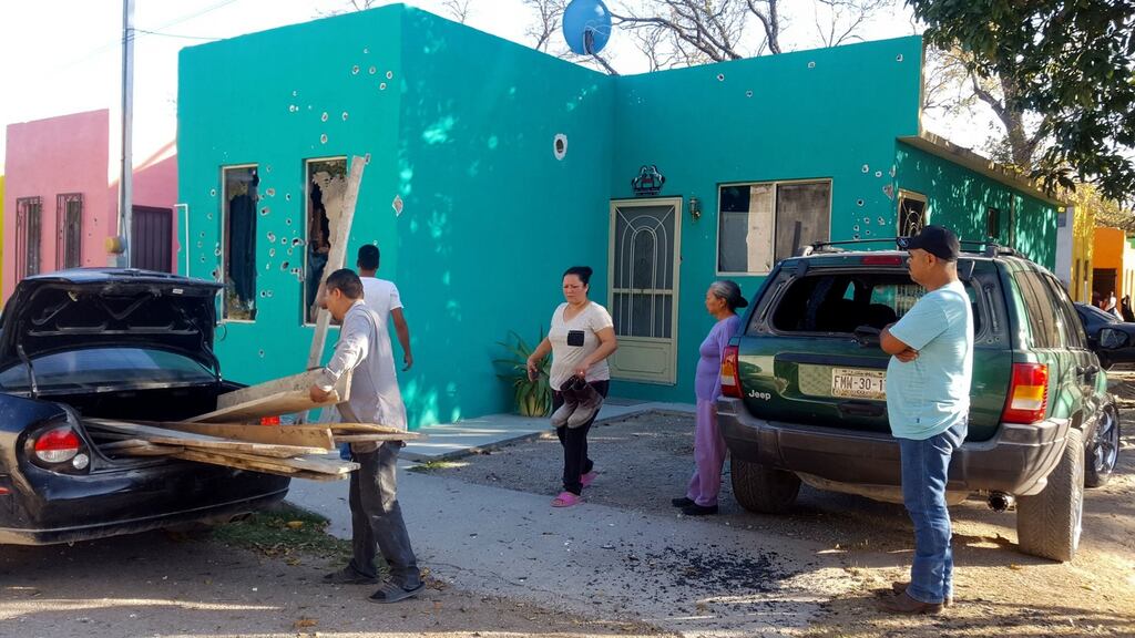 Residents stand in front of a home riddled with bullet holes after the incident in Villa Union. Photograph: AP/Gerardo Sanchez