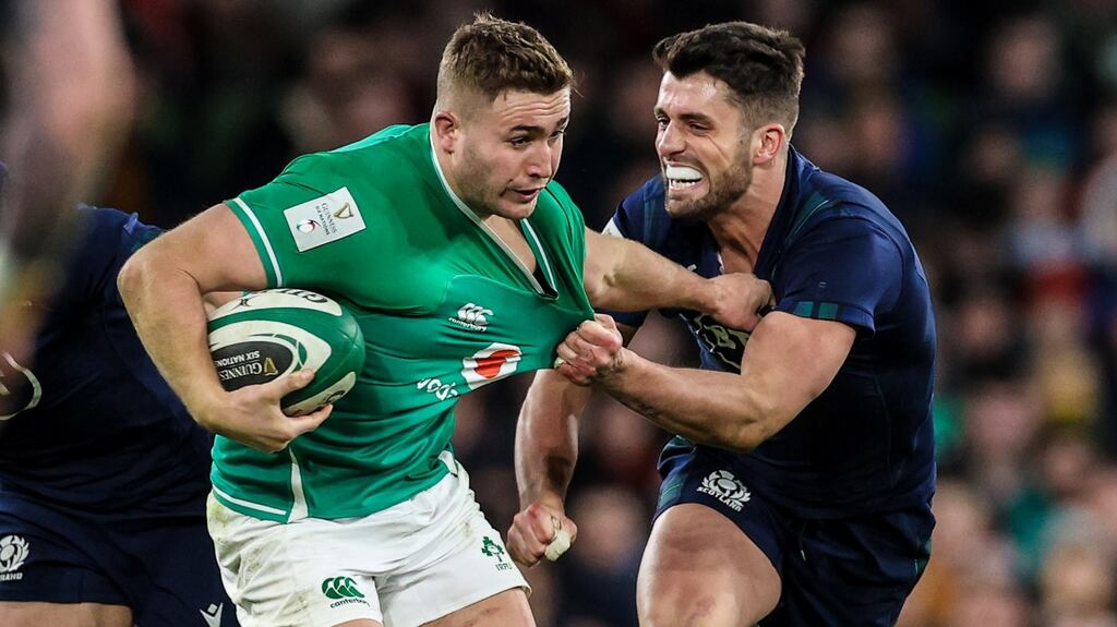 Jordan Larmour tries to hold off the challenge from Scotland’s Adam Hastings at the Aviva Stadium. Photograph: Billy Stickland/Inpho