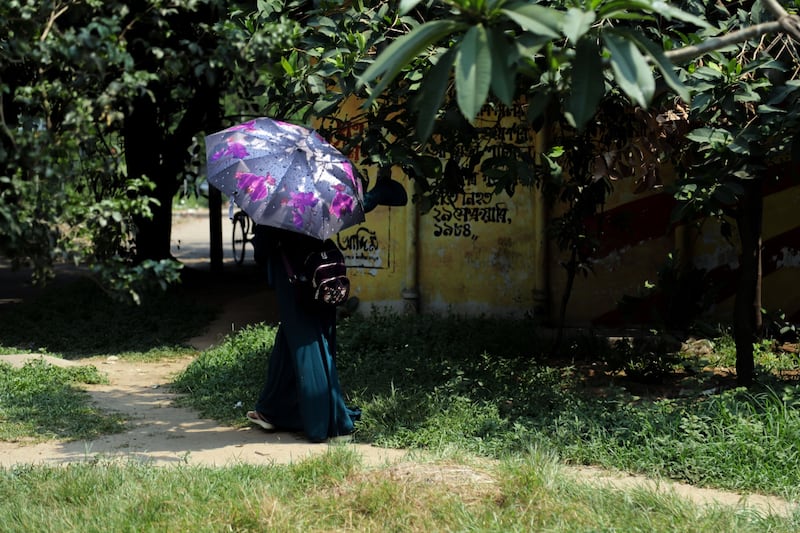 A pedestrian uses an umbrella to take shelter from the sun during high temperatures in Dhaka, Bangladesh, recently. Photograph: Anik Rahman/Bloomberg