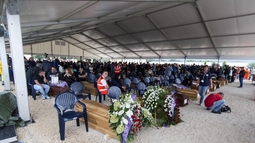 Relatives of earthquake victims sit in a tent next to coffins of their loved ones before a mass funeral in quake-devastated Amatrice, central Italy, August 30th, 2016. Construction crews worked through the night to build a tent complex to host the service after outraged residents rejected the government’s plan to hold the service in a distant airport hangar. Photograph: Massimo Percossi/EPA