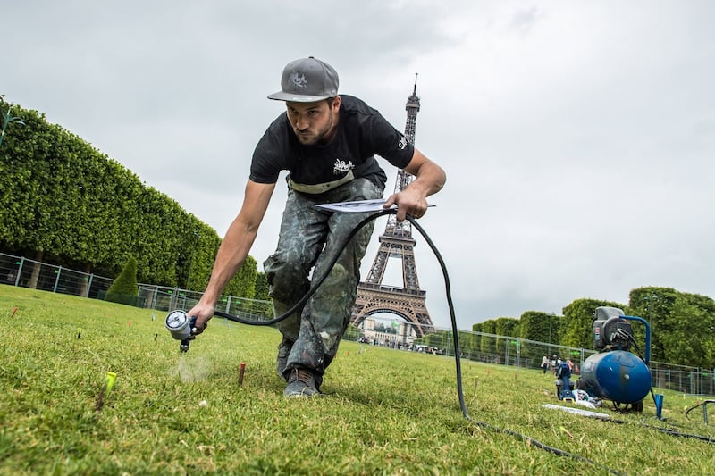 Eiffel Tower art: Saype works on his new fresco in Paris. Photograph: Christophe Petit Tesson/EPA