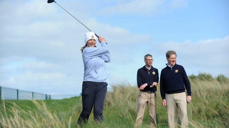 Andrea Fitzgerald, lady captain of the Castle Golf Club, Dublin, tees off watched on by Eamonn Duggan, chairman, and Barry McConville, captain, during the Allianz/The Irish Times Officers Challenge golf tournament in Portmarnock Hotel and Golf Links Dublin. Photograph: Aidan Crawley