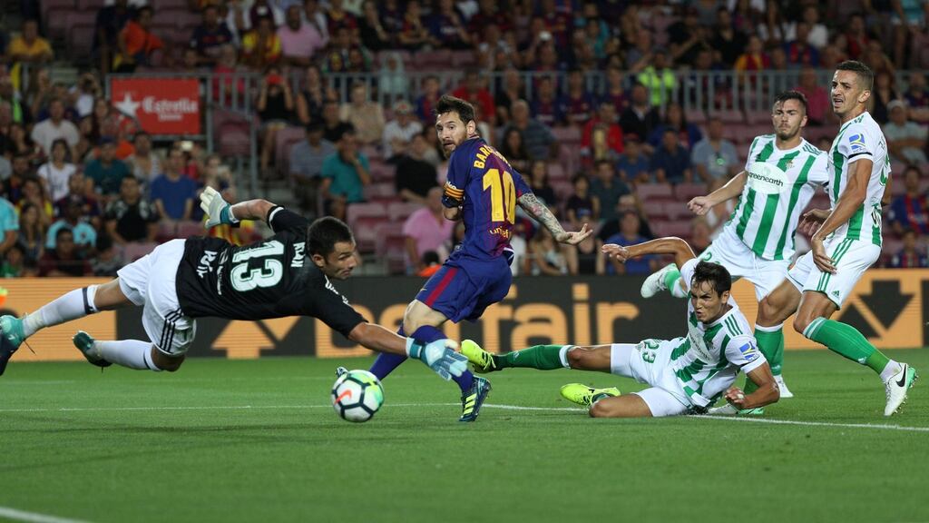 Lionel Messi looks an as Betis defender Alin Tosca scores Barcelona’s first goal Photograph: Sergio Perez/Reuters