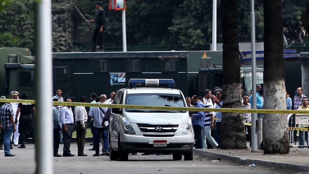 Egyptian policemen inspect the site of bombing outside Cairo University. Photograph: Khaled Elfiqi/EPA