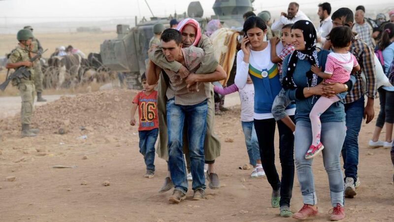 Syrian Kurds crossing into Turkey at the Turkish-Syrian border near the southeastern town of Suruc in Sanliurfa province. Further air strikes are said to have hit Islamic State targets close to an area that tens of thousands of Kurds have fled as the militant group advanced. Photograph: Reuters.