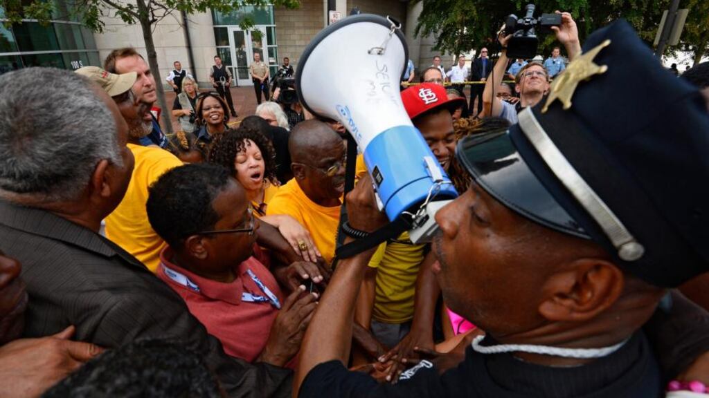 Anthony Shahid of the Tauheed youth group (right) prays with demonstrators and along with members of the Justice for Michael Brown Leadership Coalition march today near the Buzz Westfall Justice Centre where a grand jury will hear the case on the August 9th shooting of Michael Brown, after a further night of demonstrations and protests, in Clayton, Missouri. Photograph: EPA/Larry W Smith