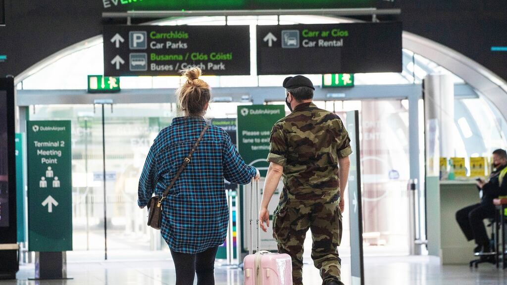 A member of the defence forces escorts a passenger from Terminal 2 arrivals hall at Dublin Airport as the State’s mandatory quarantine system was extended on Thursday to include the US, Belgium, France and Italy. Photograph: Brian Lawless/PA Wire