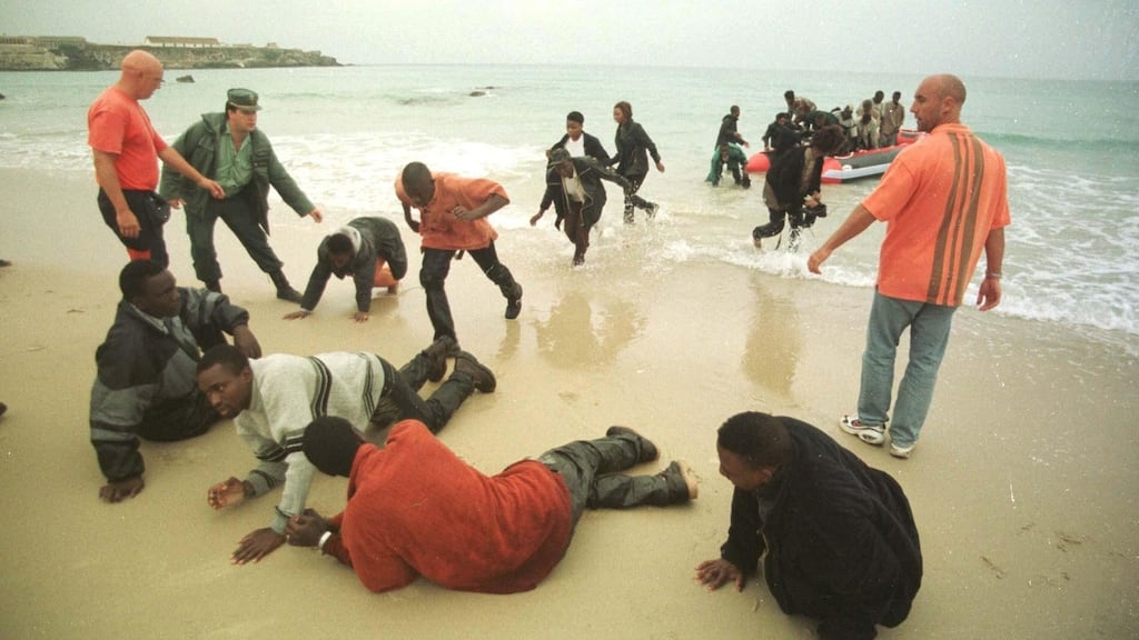 Desperate: African immigrants are arrested after their dinghy is intercepted on a Spanish beach.  In Escape Attempt, Montes plans to exploit Omar, an immigrant living in vile conditions. Photograph: J.Ragel/AP