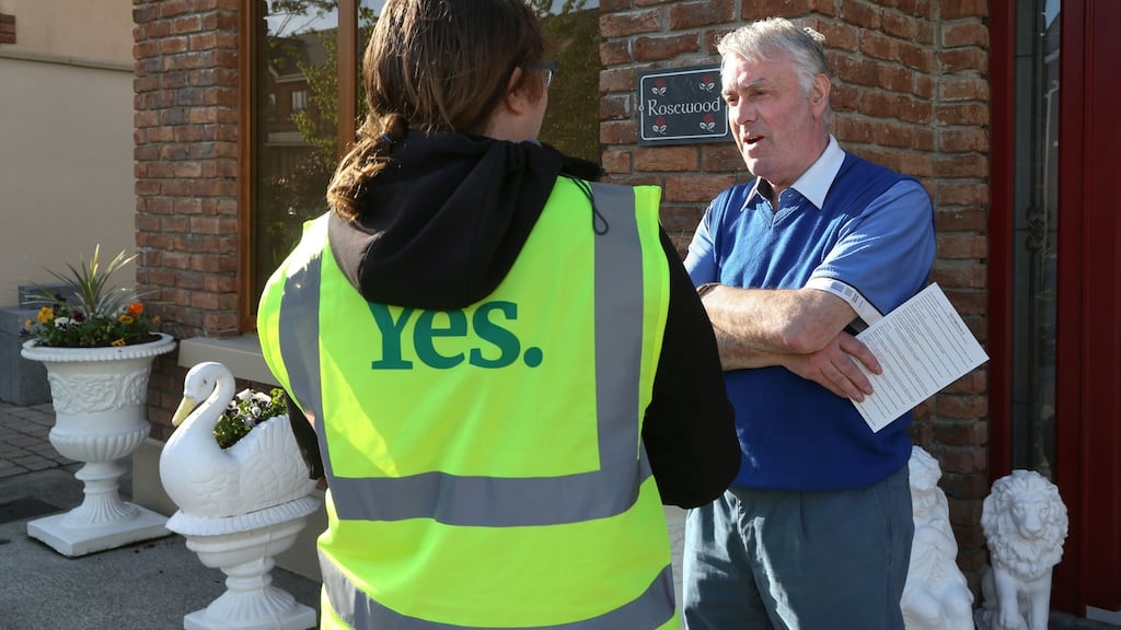 Aoife Flaherty speaking with Noel Carroll at his home during a Together for Yes house to house call in the Knocknacarra area of Galway. Photograph: Joe O’Shaughnessy