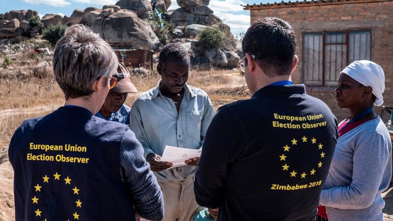 Members of a European Union election observation team speak to voters in Nyatsime, Zimbabwe. Photograph: Marco Longari/AFP/Getty Images