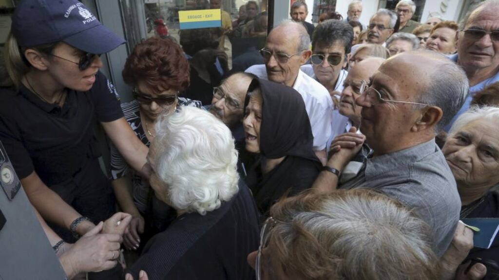 Pensioners struggle this week to enter a National Bank branch to receive part of their pension in Iraklio on the island of Crete . Photograph: Reuters/Stefanos Rapanis