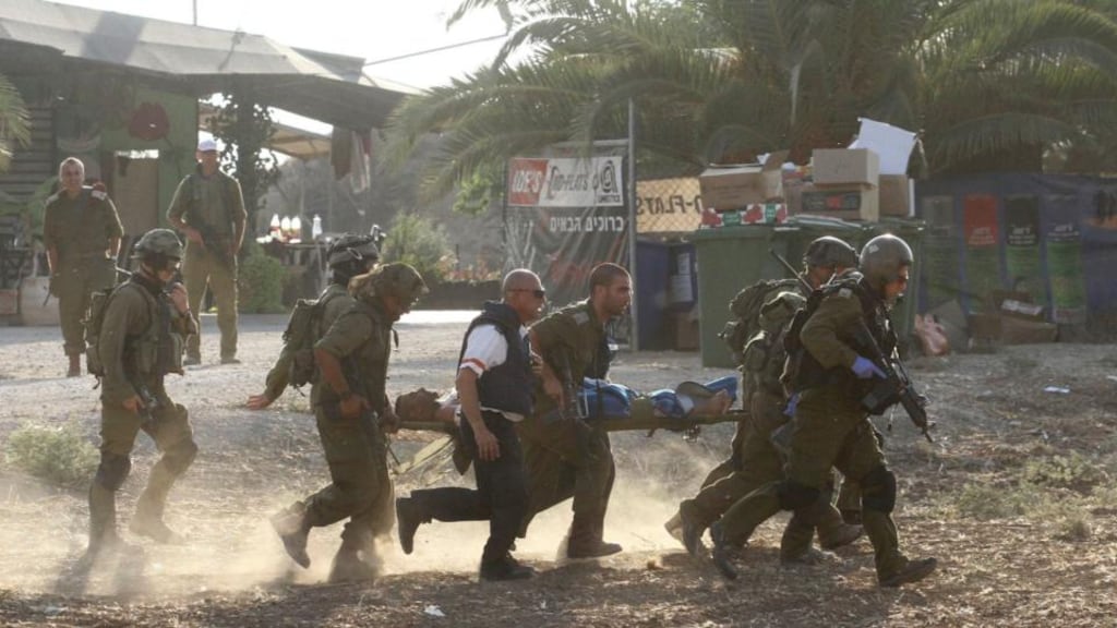 Israeli soldiers carry a comrade on a stretcher after he was wounded in a Palestinian mortar strike, as they evacuate him from the scene outside the central Gaza Strip yesterday. Photograph: Reuters/Ido Erez