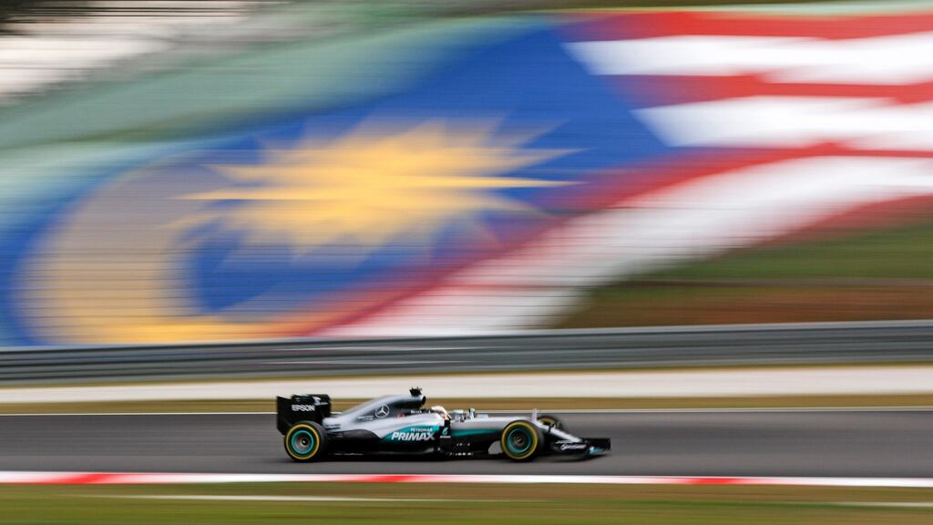 Lewis Hamilton of Mercedes AMG GP steers his car in front of a Malaysian national flag during the qualifying session for the Malaysian Grand Prix in Sepang. Photograph: EPA