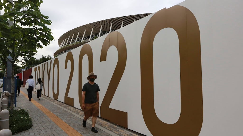 People walk past the National Stadium in Tokyo. Photo: Koji Sasahara/AP Photo