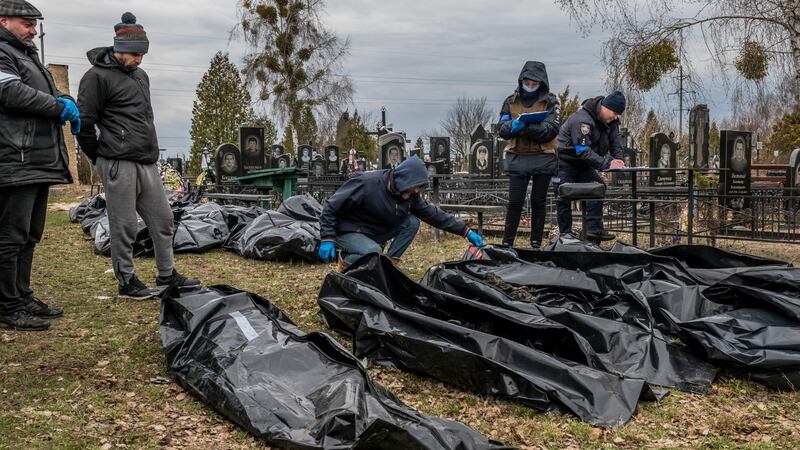 Investigators and local workers examine bodies after Russian forces retreated from Bucha in April. Photograph: Daniel Berehulak/New York Times