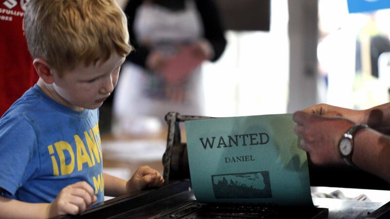 A young attendee watches “Wanted” being created the National Print Museum