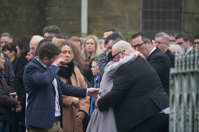 Mourners embrace the father of Matthew Healy outside the church. Photograph: Niall Carson/PA Wire