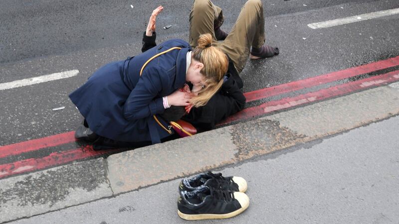 A woman assists an injured person after an incident on Westminster Bridge in London. Photograph: Toby Melville/Reuters