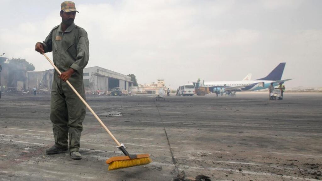 A man clears debris from the tarmac of Jinnah International Airport, in Karachi, after Sunday’s attack by Taliban militants. Photograph: Athar Hussain/Reuters